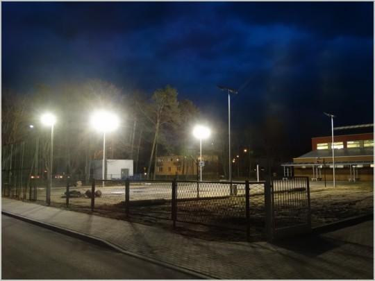 Widok na oświetlone  lampami ledowymi boisko do gry w koszykówkę.
